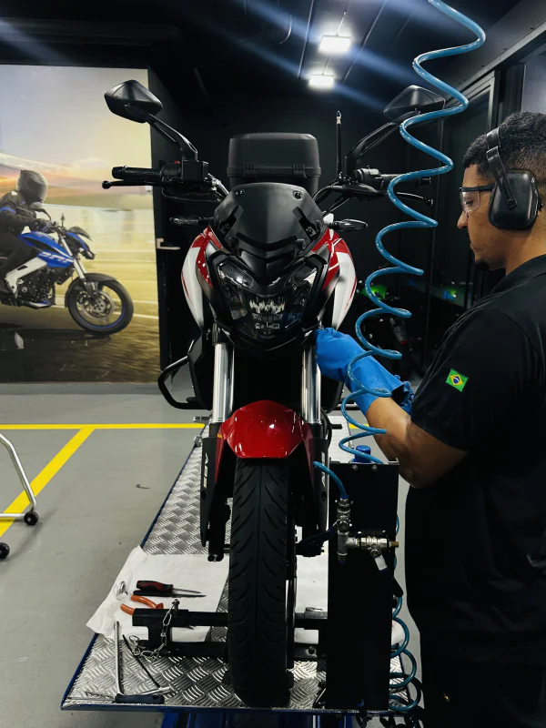 Equipe técnica Marello realizando revisão em moto Bajaj com equipamentos profissionais e suporte especializado