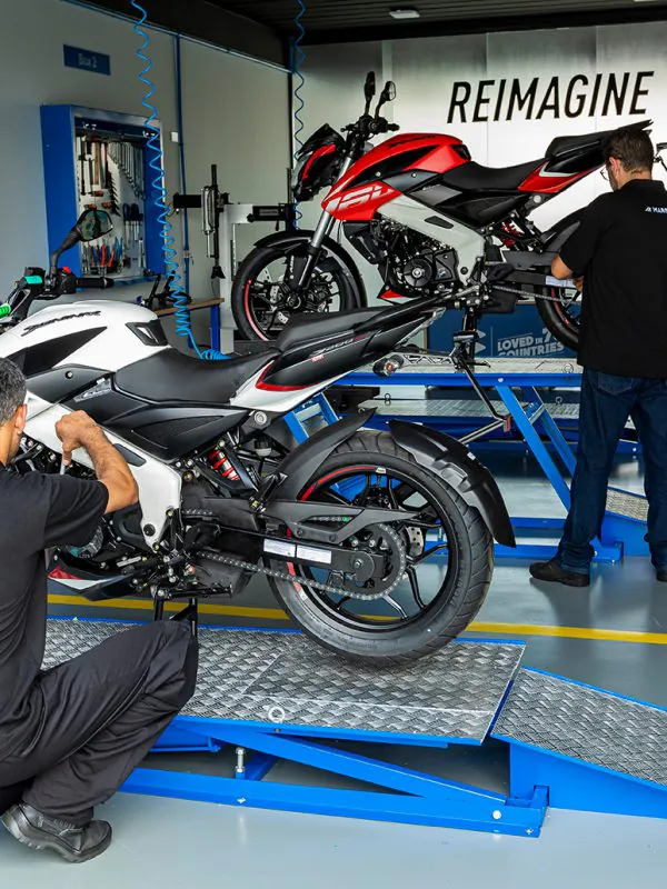 Mecânico trabalhando em moto Bajaj sobre plataforma na oficina autorizada Marello em Santo André